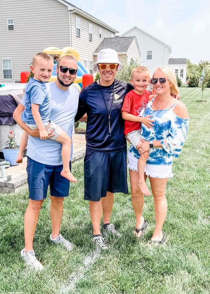 A Family Phys. Ed. coach high-fiving a smiling child