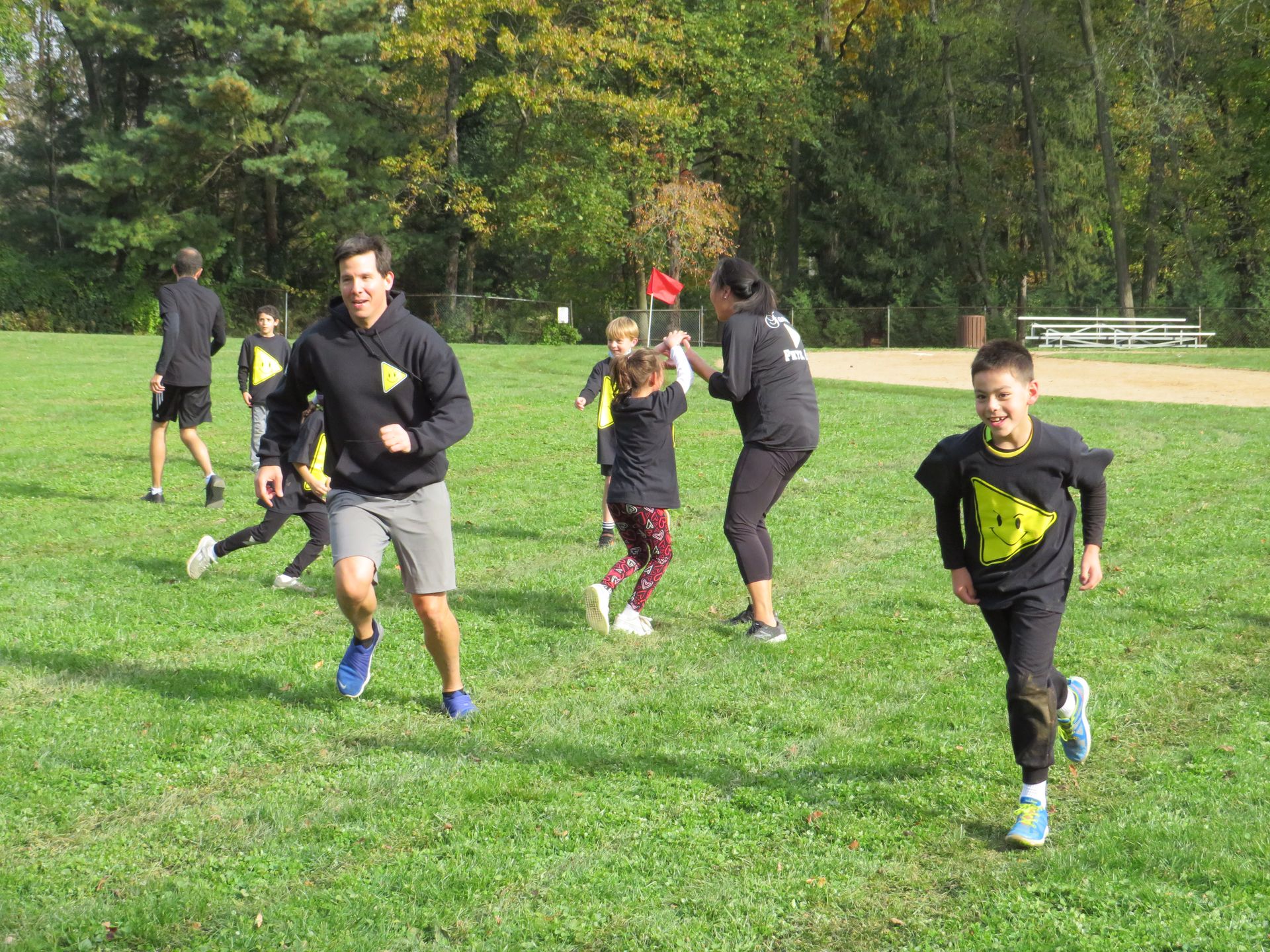 A family laughing and playing physical education games on a field